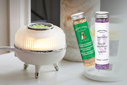 White diffuser with green and purple labeled bottles on a light surface