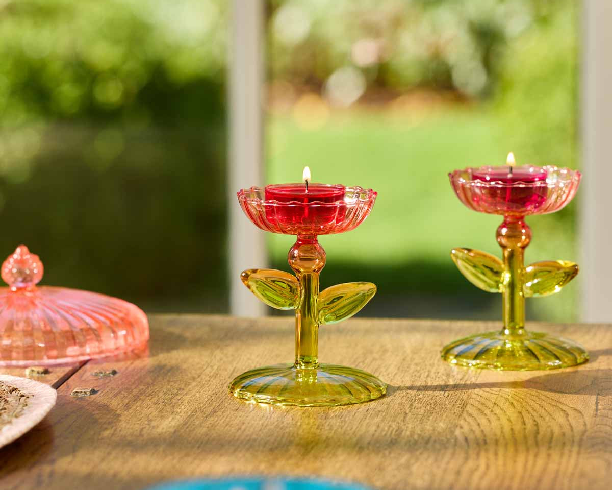 Dainty Flowers Tealight Holder Pair with lit tealights on a wooden surface.
