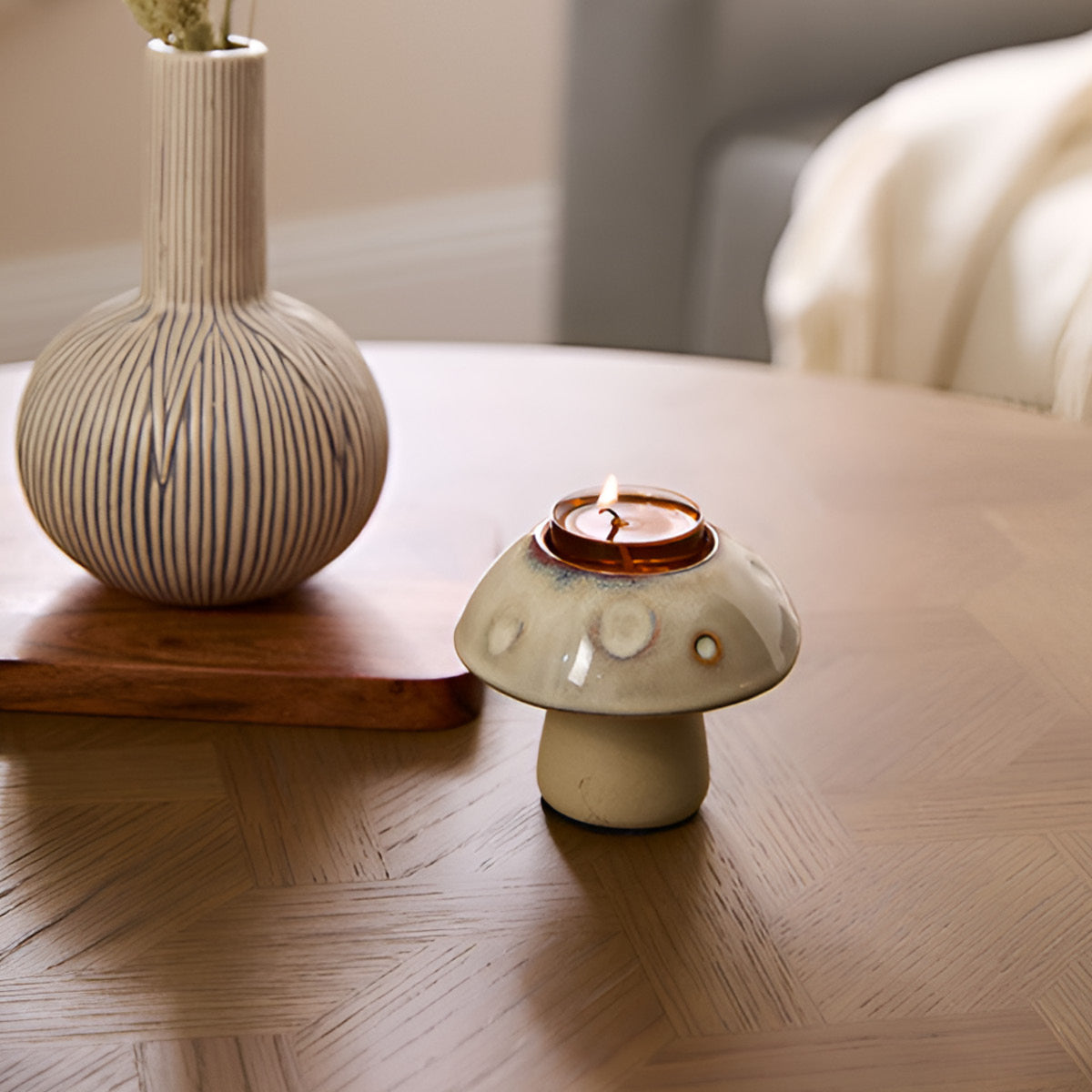 Munchkin Mushroom Tealight Holder with a vase next to it on a wooden tray on a wooden table top