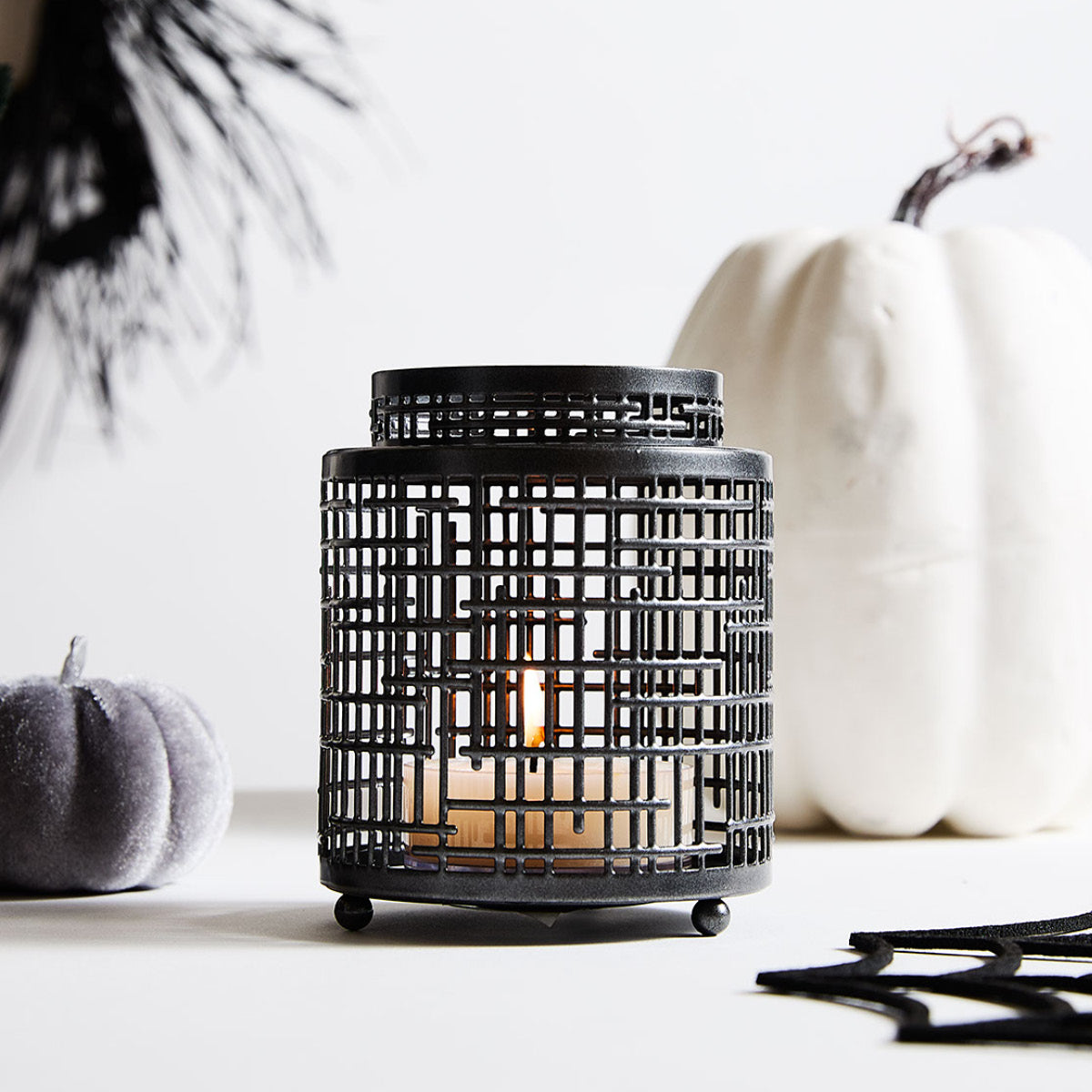 Spiced Pumpkin Large Tealight shown lit in a Hurricane with decorate pumpkins against a white background