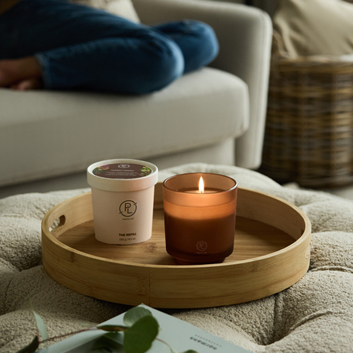 Refillable Jar shown with Refillable wax on a wooden tray with a sofa in the background 